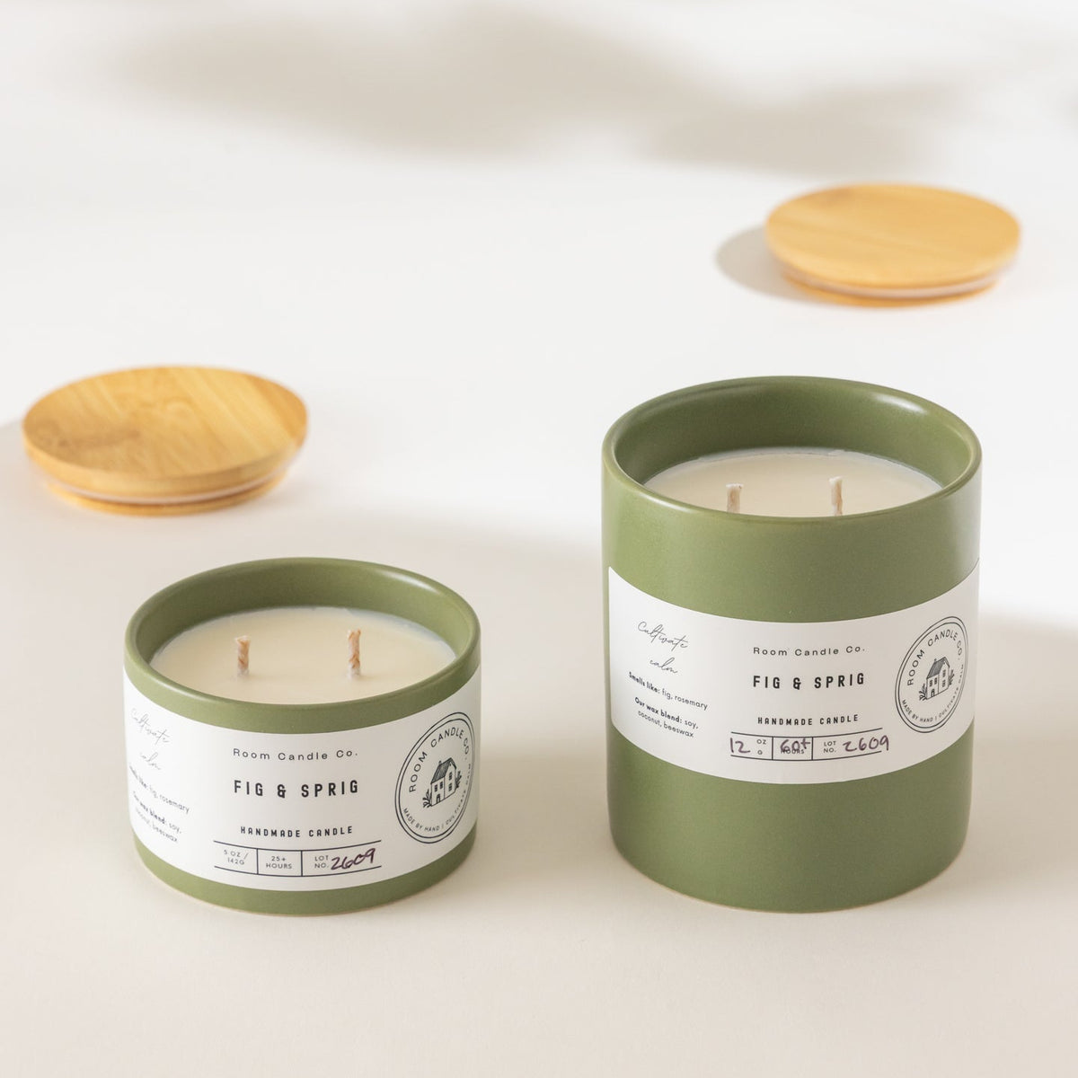 Two Fig and Sprig candles by Room Candle Co. in 5 oz and 12 oz sizes, displayed in green ceramic vessels against a plain background.